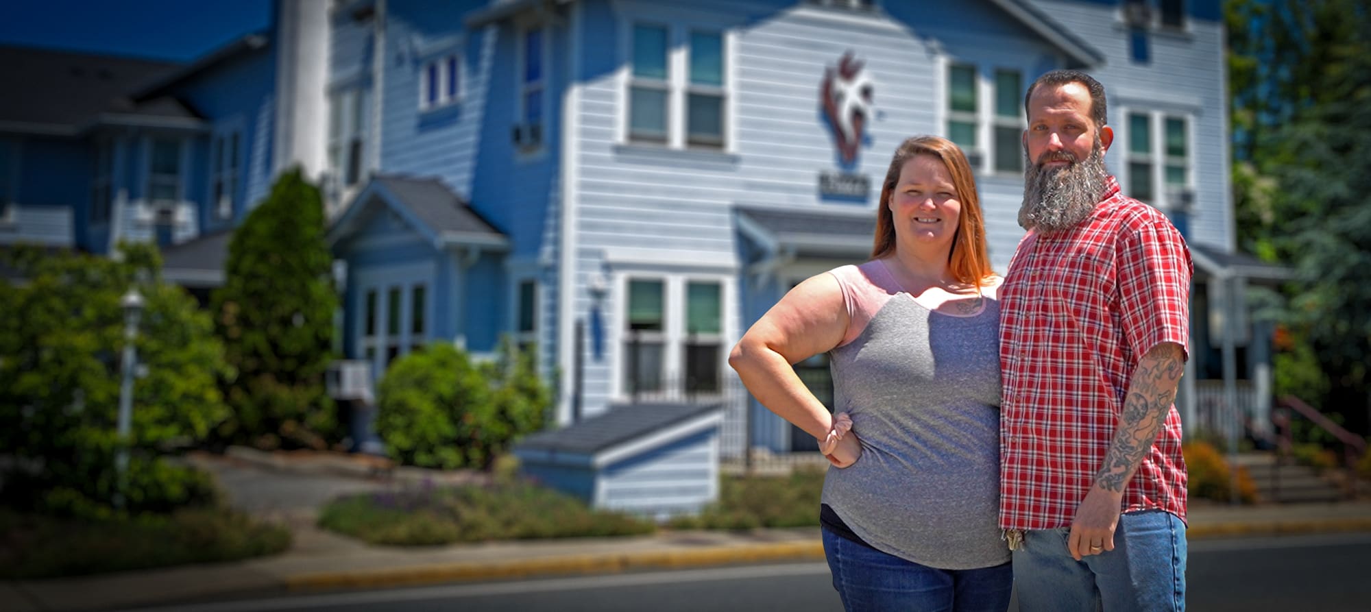 Married Staff Members Greg and Monica Stand in Front of Fikso Family Center