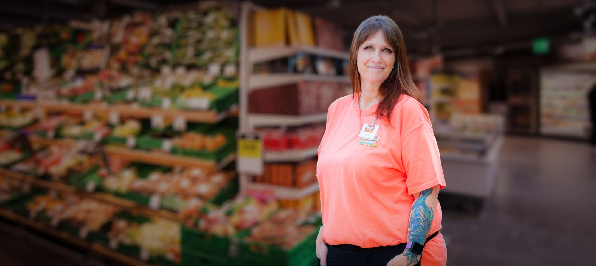 Jennifer in grocery store wearing work uniform.
