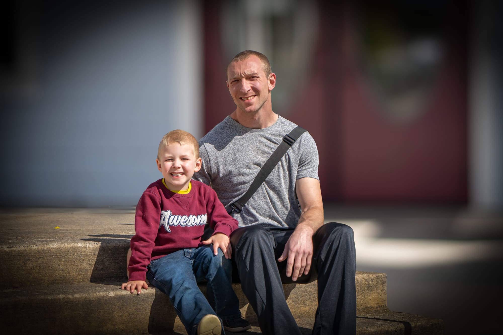 Skyler and his Son sit on the Mission steps.